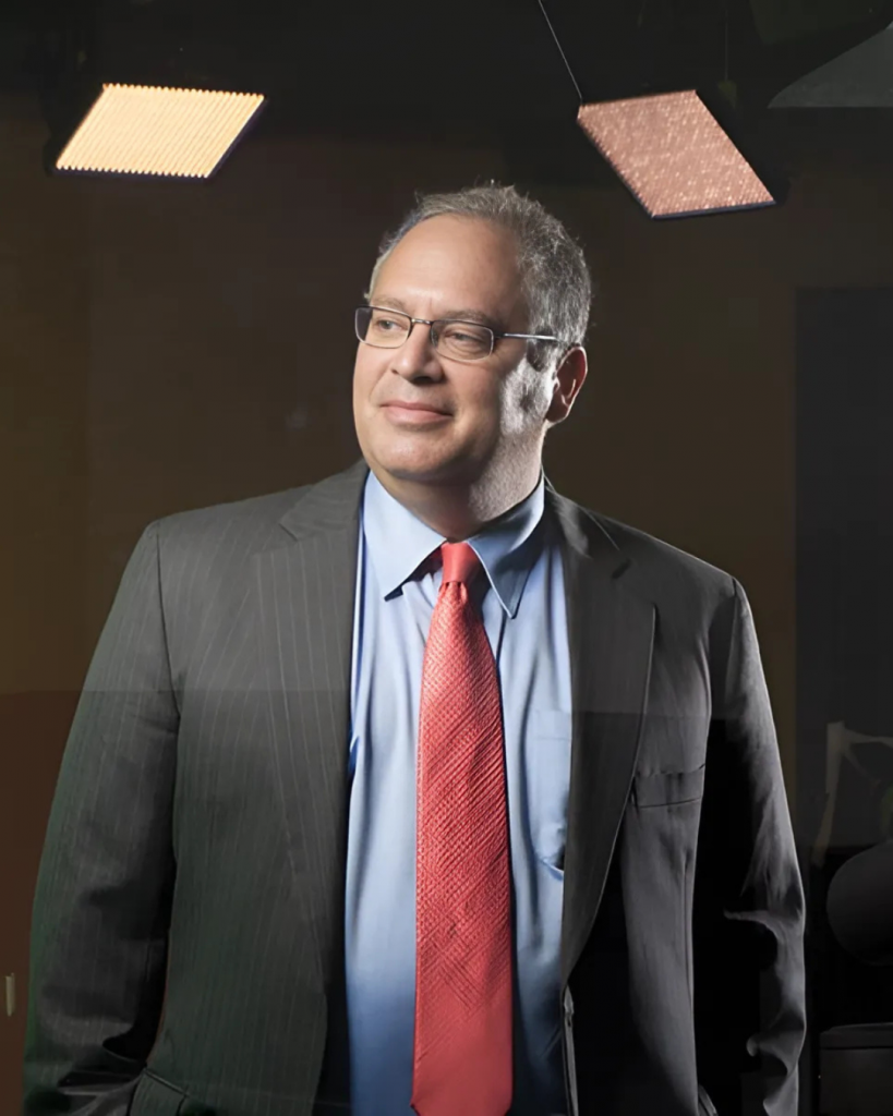 a man in a black suit and red tie